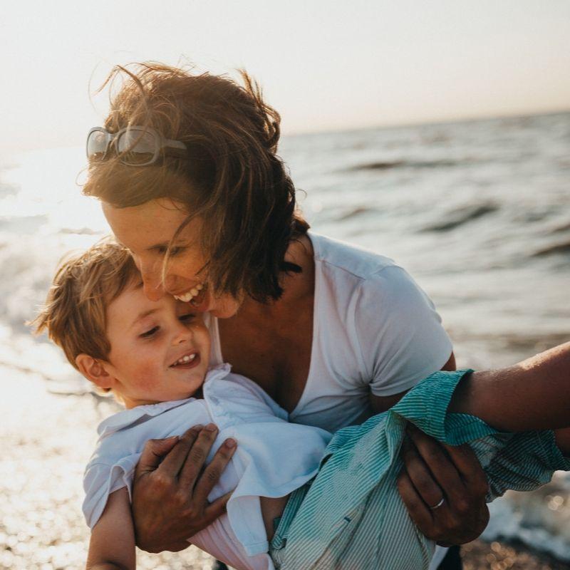 Mum playing with her child on the beach