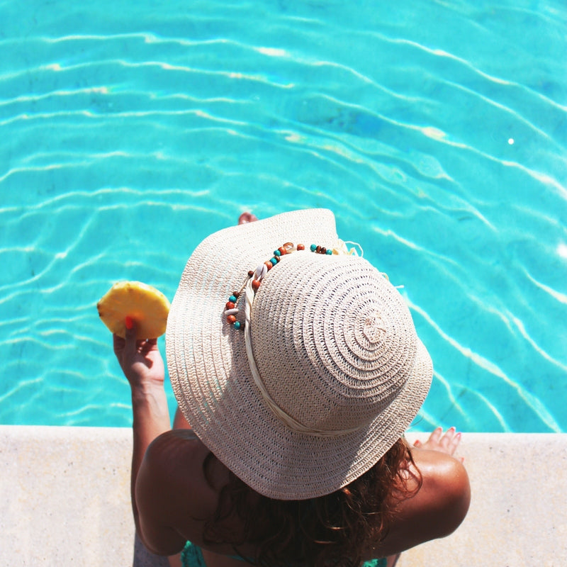 woman with a hat by the pool